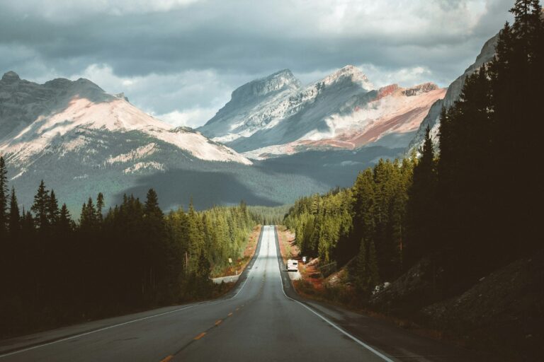 open road leading to the majestic rocky mountains in Alberta