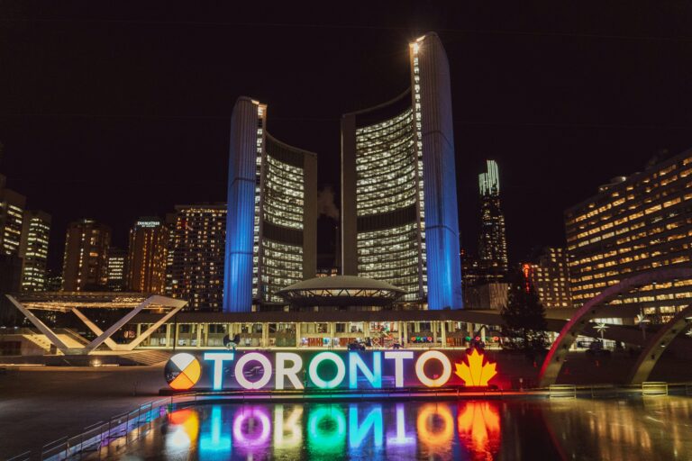 Night phono of the Toronto City Hall. The Toronto sign letters are all lite up in different colours.
