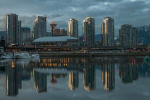 Vancouver skyline in the early evening with reflections of the skyline on the bay.