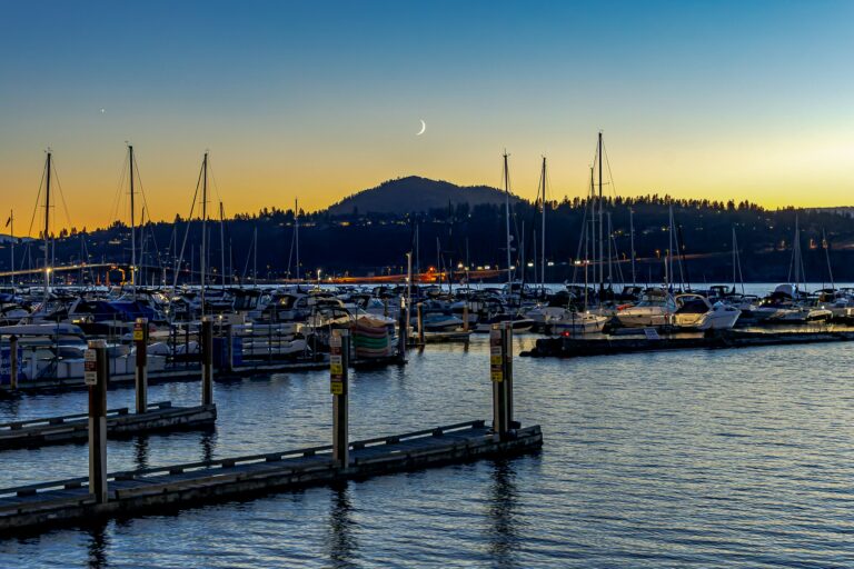 sunset over the Kelowna marina with the moon resting above a mountain